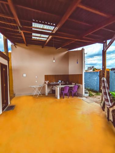 a large patio with a table and purple chairs at Água Doce Hospedagemw in Sao Jorge
