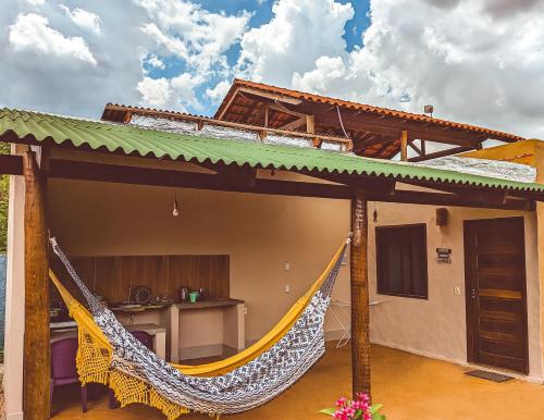 a patio with a hammock in front of a house at Água Doce Hospedagemw in Sao Jorge