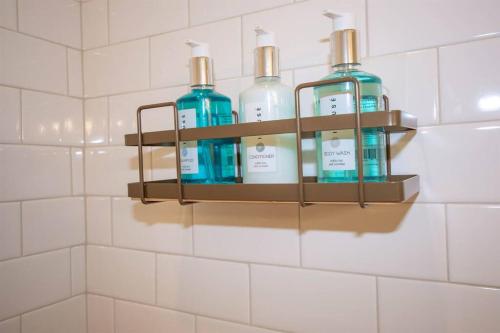 four bottles of soap on a shelf in a bathroom at Oxford The Hotty Toddy House in Oxford