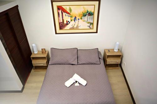 a bedroom with a bed with a bow tie on it at Apartahotel La Arboleda HC in Manizales