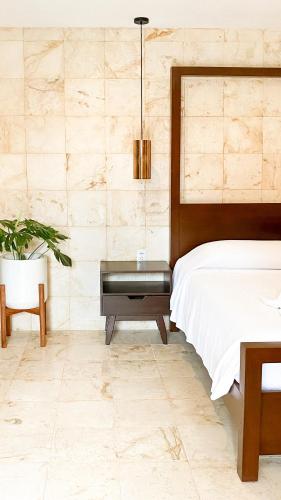 a bedroom with a bed and a table with a piano at La Aurora Hotel Colonial in Valladolid