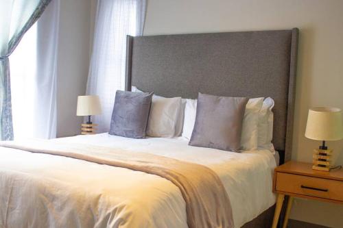 a bedroom with a large bed with white sheets and pillows at 11 Elizabeth Place - Luxury Apartments, Free Wi-Fi in Midrand