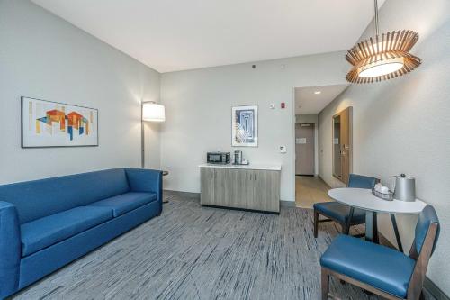 uma sala de estar com um sofá azul e uma mesa em Holiday Inn Express and Suites North Charleston, an IHG Hotel em Charleston