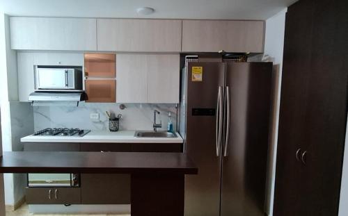 a kitchen with a stainless steel refrigerator and a sink at Casalba in Bello