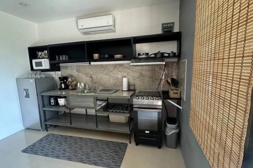 uma pequena cozinha com um fogão e um frigorífico em Villa Bienvenida Costa Rica em Santa Cruz