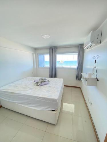 Habitación blanca con cama y ventana en Apartamento beira mar Salvador Bahia, en Salvador