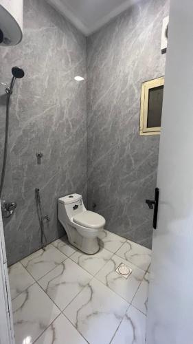 a bathroom with a white toilet in a room at Your first comfortable residence in Riyadh