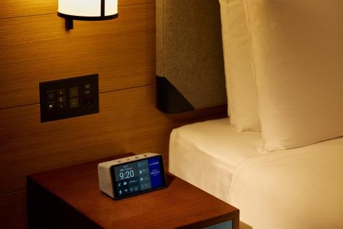 a room with a bed and an alarm clock on a table at Hotel Indigo Hakone Gora by IHG in Hakone