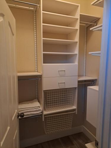 a walk in closet with white drawers and shelves at Roseville Properties in Roseville