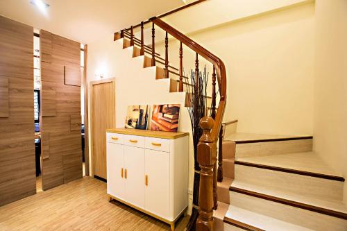 a staircase in a house with a white cabinet at Traveller-Inn Zhongzheng Library in Taitung City