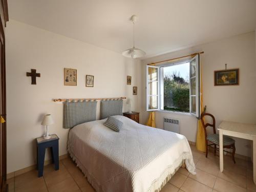 una camera con un letto e una croce sul muro di Villa La Couarde-sur-Mer, 6 pièces, 8 personnes - FR-1-258-49 a La Couarde-sur-Mer