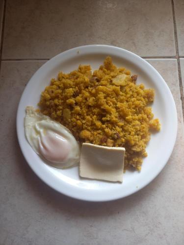 a plate of food with rice and a stick of butter at Finca La Esperanza in Palora