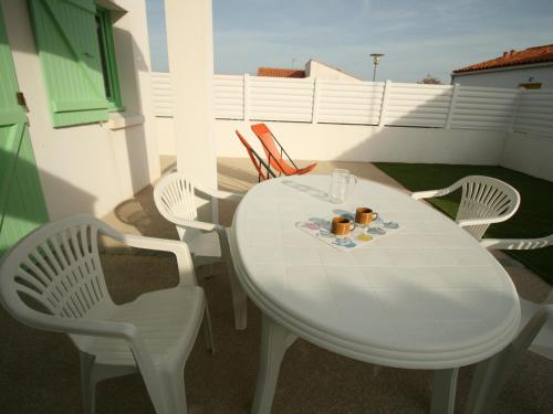 une table blanche et des chaises sur un balcon dans l'établissement Maison cosy à 900m de la plage avec jardin clos et parking privatif - FR-1-22-182, à La Tranche-sur-Mer