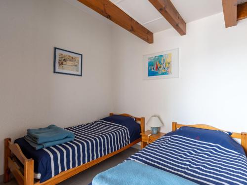 deux lits jumeaux dans une chambre aux murs blancs dans l'établissement Maison T3 Biscarrosse Plage - Piscine - Terrasse - Près des Dunes - FR-1-319-173, à Biscarrosse-Plage