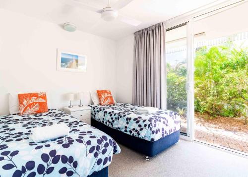 two beds in a room with a window at Secret Gem in Peregian Beach
