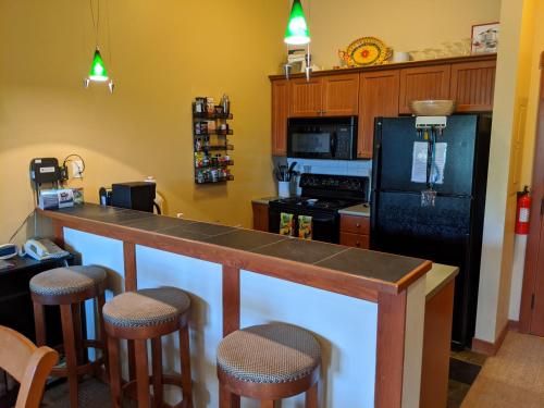 a kitchen with a counter and a black refrigerator at Stunning at Solitude, Steps from Chair Lift, East #103 in Brighton