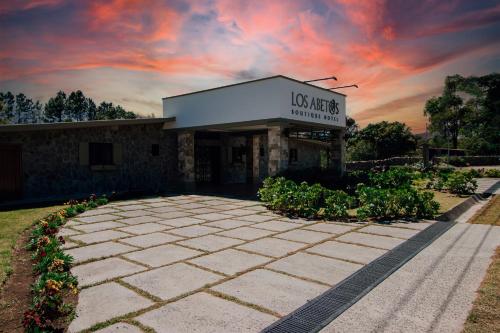 a building with a sunset in the sky at Hotel Boutique Los Abetos in Boquete