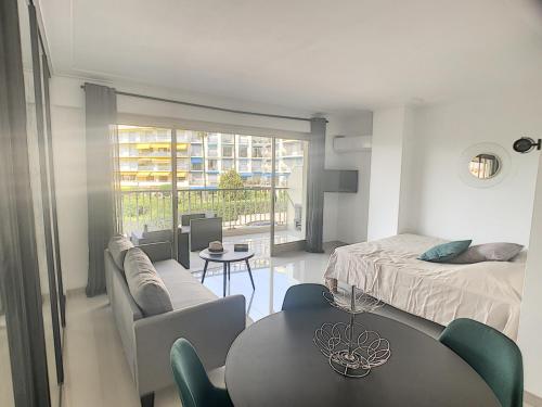 Studio Cannes, 1 pièce, 2 personnes - FR-1-470-50 في كان: غرفة معيشة مع سرير وطاولة