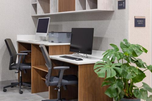 an office with a desk with a computer and two chairs at La Quinta Inn & Suites by Wyndham Williston Burlington in Williston