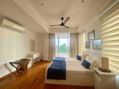 a bedroom with a bed and a ceiling fan at Oceanfront condo 3-2-01- Nilaveli in Nilaveli