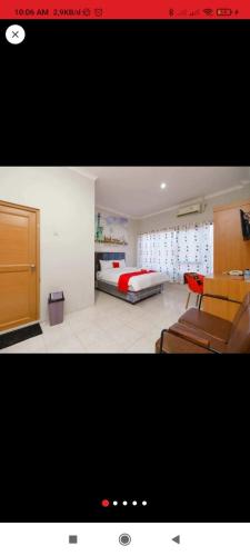 une photo d'une chambre avec un lit et un canapé dans l'établissement Reddoorz near JIEXPO Kemayoran 2, à Jakarta