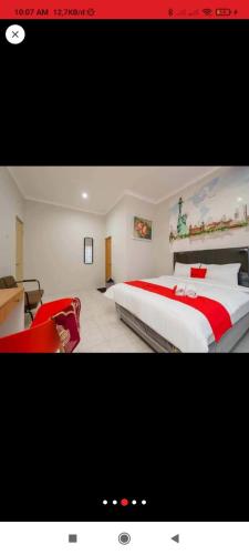 - une chambre dotée d'un grand lit avec des draps rouges et blancs dans l'établissement Reddoorz near JIEXPO Kemayoran 2, à Jakarta