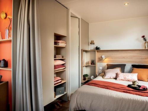 een slaapkamer met een bed en enkele planken bij Mobil-Home Jullouville, 4 pièces, 6 personnes - FR-1-361A-9 in Jullouville-les-Pins