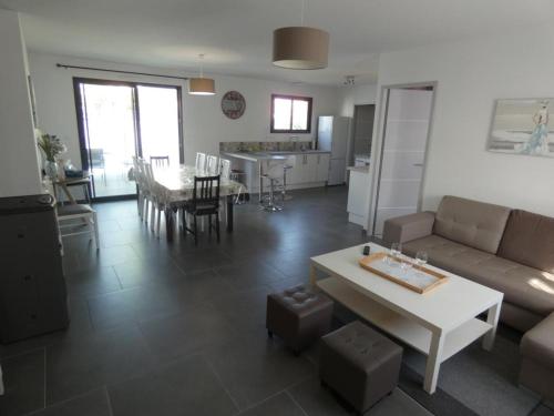 un salon avec un canapé et une table dans l'établissement Maison 85m² à Notre-Dame-de-Monts, 7 pers, proche plage, 3 chambres, terrasse, activités nautiques - FR-1-540-150, à Notre-Dame-de-Monts