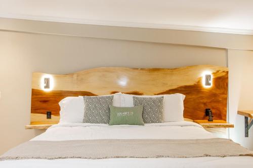 a bedroom with a bed with a wooden headboard at Hotel Boutique Los Abetos in Boquete