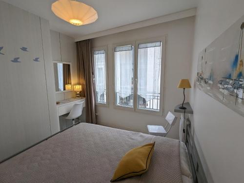 une chambre avec un lit et deux fenêtres dans l'établissement Arcachon centre, T2 de 47m², 200m plage, loggia, parking, idéal couple - FR-1-420-109, à Arcachon