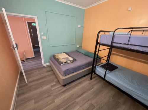 Pokój z 2 łóżkami piętrowymi i korytarzem w obiekcie The Cozy Hostel - Motel w mieście Darwin