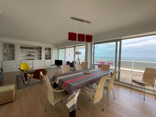 une salle à manger avec une table et des chaises et l'océan dans l'établissement Appartement 4 chambres au dernier étage avec immense terrasse face au Bassin à Arcachon - FR-1-420-122, à Arcachon