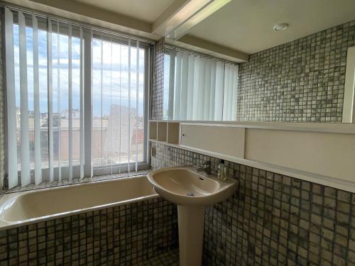 une salle de bain avec un lavabo et une fenêtre dans l'établissement Appartement 4 chambres au dernier étage avec immense terrasse face au Bassin à Arcachon - FR-1-420-122, à Arcachon
