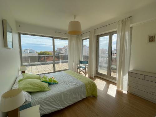 une chambre avec un lit et une grande fenêtre dans l'établissement Appartement 4 chambres au dernier étage avec immense terrasse face au Bassin à Arcachon - FR-1-420-122, à Arcachon