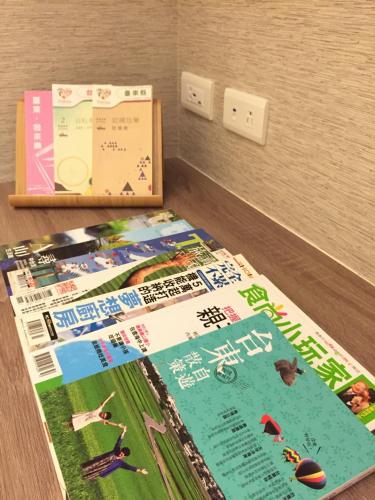 a pile of brochures on a table next to an outlet at Traveller-Inn Zhongzheng Library in Taitung City