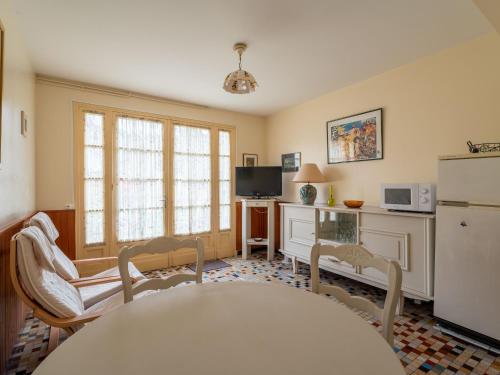 une cuisine avec une table, des chaises et un réfrigérateur dans l'établissement Appartement 4 pers, Pieds des Pistes Cyclables, Terrasse, BBQ, Proche Plages et Activités - FR-1-50-107, à Mimizan