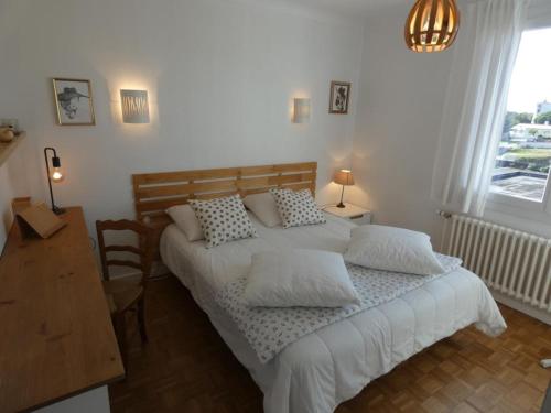 une chambre avec un lit, une table et une fenêtre dans l'établissement Maison spacieuse à Notre-Dame-de-Monts, proche plage, 3 chambres, terrasse et parking sécurisé - FR-1-540-179, à Notre-Dame-de-Monts