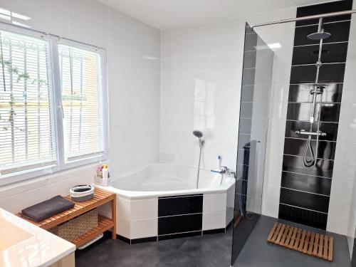 une salle de bain blanche avec une baignoire et une douche dans l'établissement Villa avec Piscine à 15 min de La Rochelle, Proche Plages et Commerces - FR-1-706-13, à Angoulins-sur-Mer