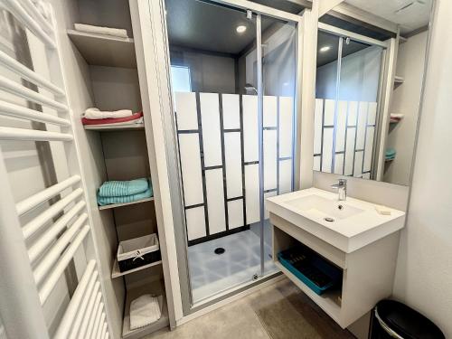 une salle de bain avec un lavabo et une douche dans l'établissement Chalet cosy avec piscine chauffée, terrasse et parking à 2 pas de la plage de Jullouville - FR-1-361-480, à Jullouville