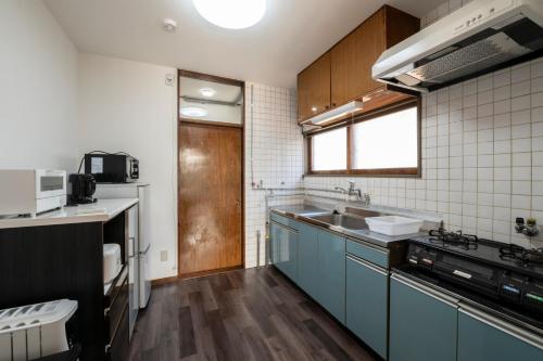 a kitchen with blue cabinets and a sink at HATSUNE in Otaru