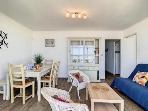 un salon avec une table et un canapé bleu dans l'établissement Confortable F5 sur plage avec parking - FR-1-715-69, à Mauguio