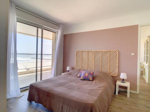 une chambre avec un grand lit avec vue sur l'océan dans l'établissement Confortable F5 sur plage avec parking - FR-1-715-69, à Mauguio