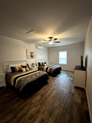 1 dormitorio con 2 camas y ventilador de techo en Howdy Hideaway, en Magnolia
