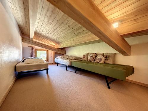 Cette chambre comprend un canapé vert et un lit. dans l'établissement Superbe 3 Pièces avec Balcons en Plein Cœur de Combloux - Parking, Wifi, Lave-linge - FR-1-560-106, à Combloux