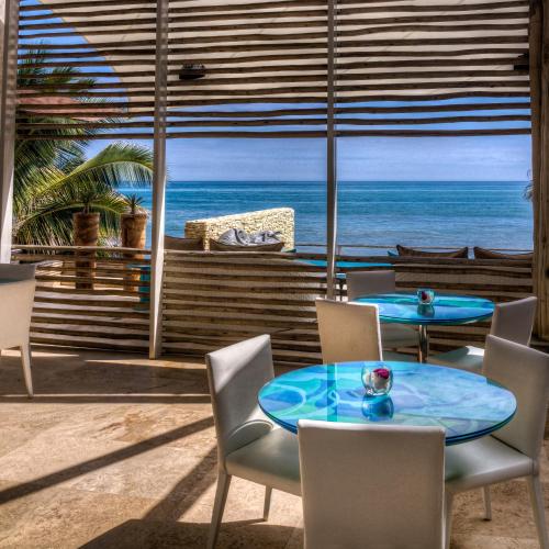a table and chairs with a view of the ocean at DCO Suites Lounge & Spa in Máncora