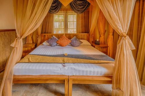 a bedroom with a bed with drapes at The Water Garden Hotel in Candidasa