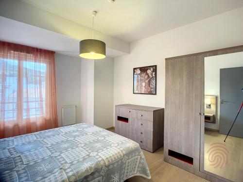 une chambre avec un lit, une commode et un miroir dans l'établissement Appartement F2 PMR, climatisé, avec terrasse et parking privé, au cœur de Lamalou-les-Bains - FR-1-451-194, à Lamalou-les-Bains