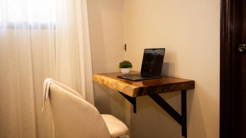 a laptop computer sitting on a wooden table in a room at Hotel Boutique Los Abetos in Boquete