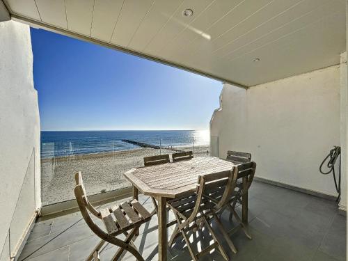 une table et des chaises sur un balcon avec vue sur la plage dans l'établissement F2 cabine rénové sur plage avec parking à Carnon - FR-1-715-78, à Mauguio