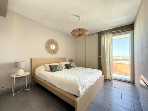 une chambre avec un lit et une grande fenêtre dans l'établissement F2 cabine rénové sur plage avec parking à Carnon - FR-1-715-78, à Mauguio